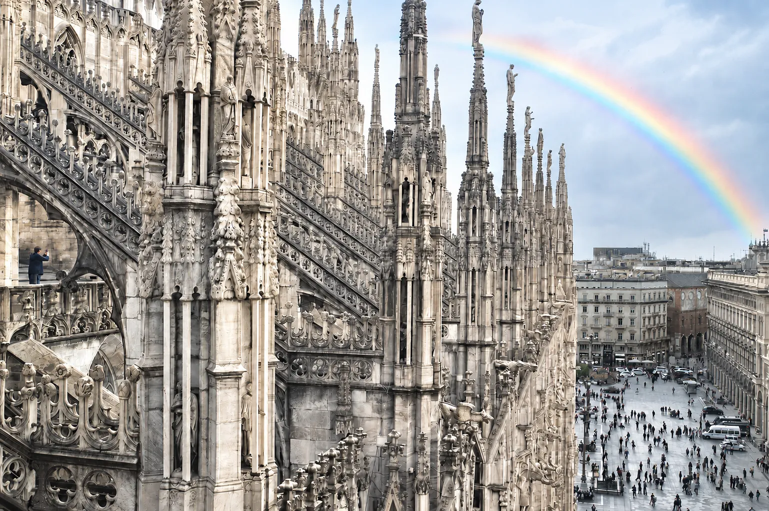 Le guglie del Duomo di Milano viste dalle terrazze, con un arcobaleno sopra la piazza